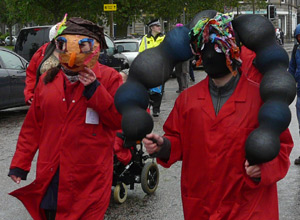 Two people in red warehouse coats with home made masks
