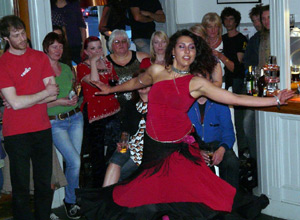 Woman dancing with extended arms and swirling magenta dress