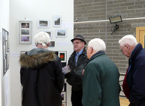 Four older men looking at photographs