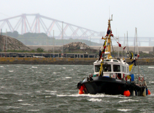 Boat sailing across the Firth of Forth with the Forth Rail Bridge in the background