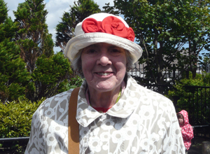 Woman in white hat decorated with red fabric roses