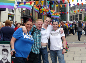 Four smiling women in tee shirts with their arms round each other