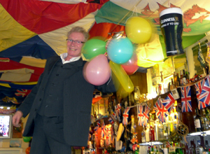 Man in charcoal grey three piece suit hanging up balloons