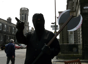 Man dressed as executioner in Constitution St pointing