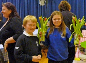 A boy and a girl clearing the tulip table decorations away