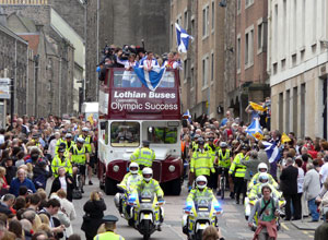 Long view of the bus with police motorcyclists in front