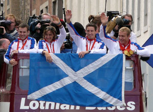 Close up of the Olympians with the Saltire draped down over the top of the bus